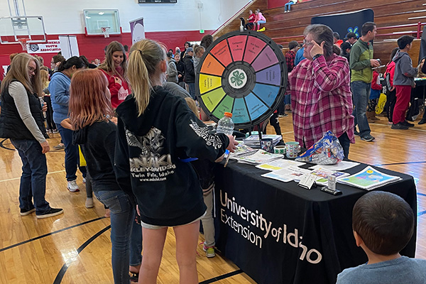 A group of people stand around a University of Idaho information table. Click to enlarge.
