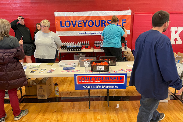 A woman answering questions at the Love Yourself information table. Click to enlarge.
